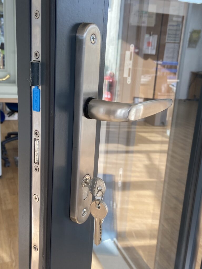 aluminium bi fold doors with brushed steel handle and key lock detail finished in anthracite grey bifold doors trinity windows jersey 2500