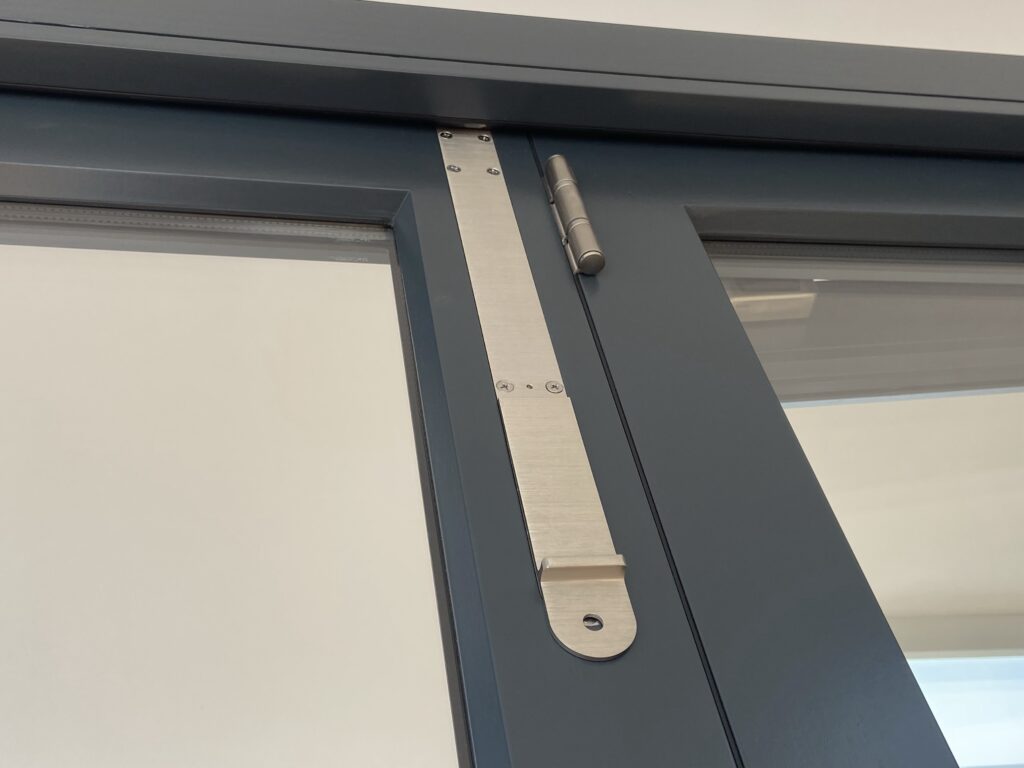 aluminium bi fold doors with security hinge reinforcement plate finished in anthracite grey bifold doors trinity windows jersey 2500