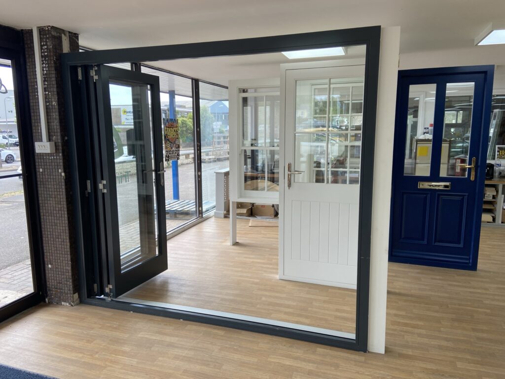 aluminium bi fold doors with slimline frames finished in anthracite grey fully open view bifold doors trinity windows jersey 2500